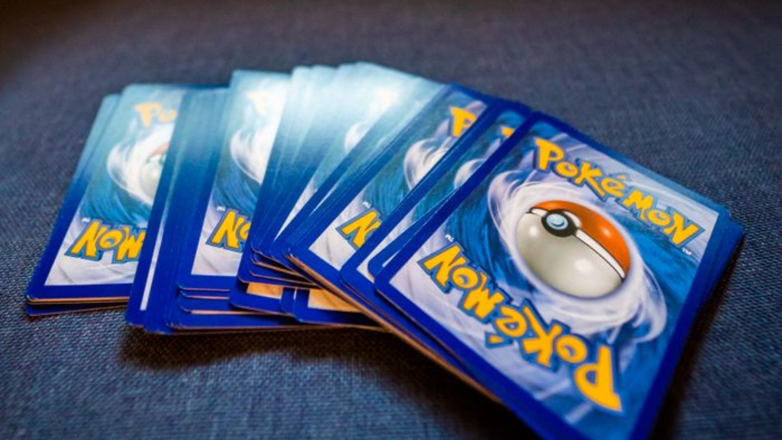 A collection of Pokemon trading cards arranged on a blue couch, ideal for collectors and fans.