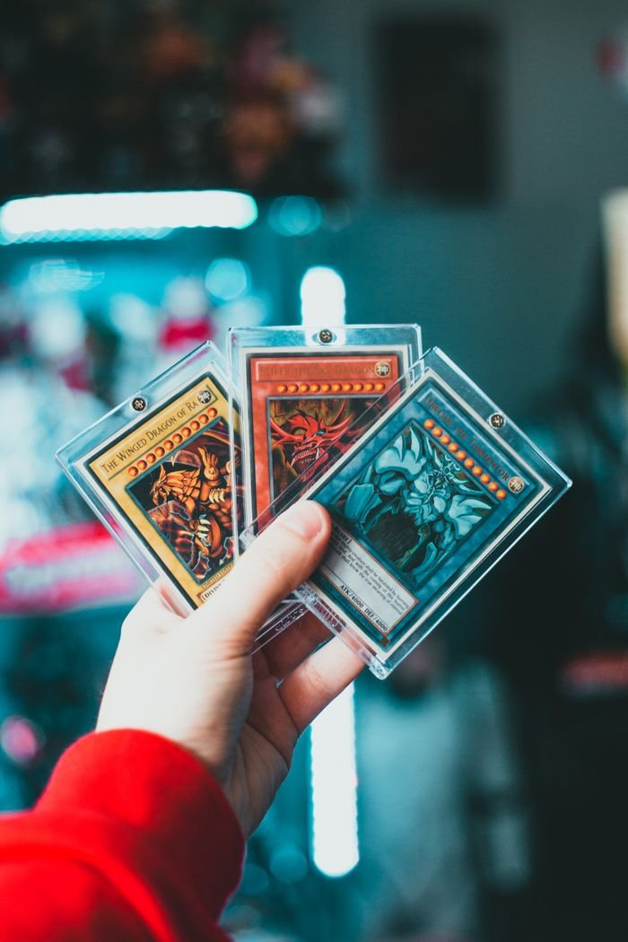 The Art of Drawing Readers In: Your attractive post title goes here Close-up of a hand holding collectible trading cards in protective cases.